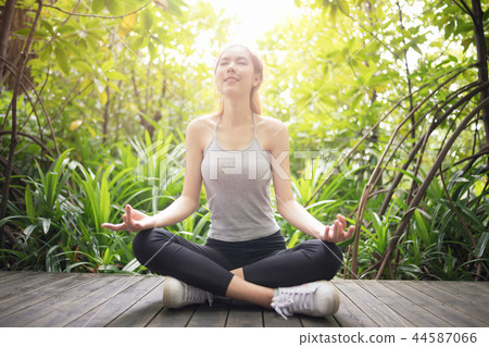 Asian woman relaxing yoga pose at the park. Asian woman relaxing yoga pose at the park. 44587066