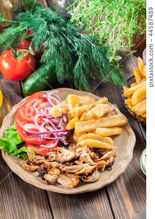 Greek gyros dish with french fries and vegetables Greek gyros dish with french fries and vegetables 44587489