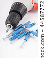 New screwdriver with screws and dowels close-up 44587772