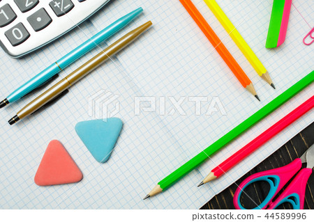 On the notebook there are pens, pencils, calculators On the notebook there are pens, pencils, calculators 44589996