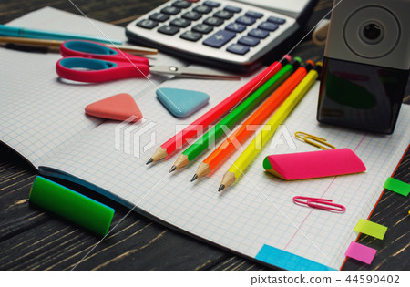 On the notebook there are pens, pencils, calculators On the notebook there are pens, pencils, calculators 44590402