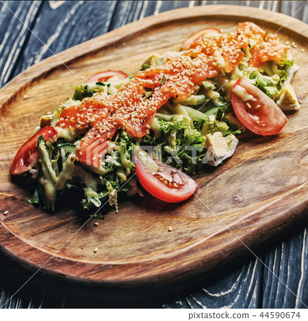 Red fish with sesame on vegetables On the black wooden table Red fish with sesame on vegetables On the black wooden table 44590674