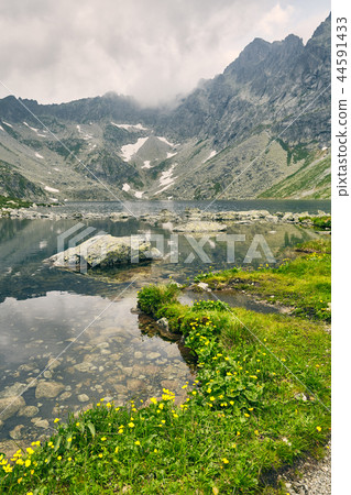 Hincovo pleso. Pure lake with a rocky bottom on the background of the mountains of the High Tatras Hincovo pleso. Pure lake with a rocky bottom on the background of the mountains of the High Tatras 44591433