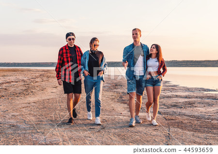 friends on beach together walking during sunset friends on beach together walking during sunset 44593659