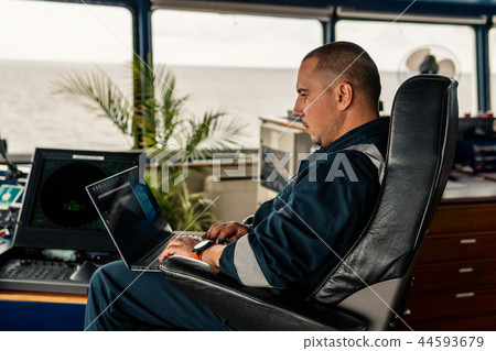 Marine navigational officer is using laptop or notebook at sea 44593679