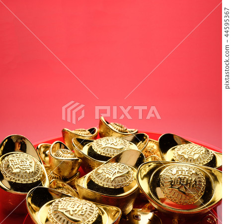 group of golden ingots on red tray at red 44595367