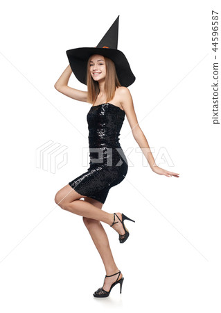 Full length playful Halloween witch on white background 44596587