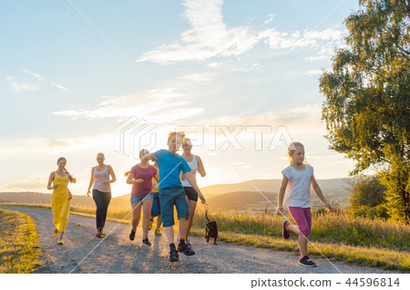 Playful family running and playing on a path in summer landscape Playful family running and playing on a path in summer landscape 44596814