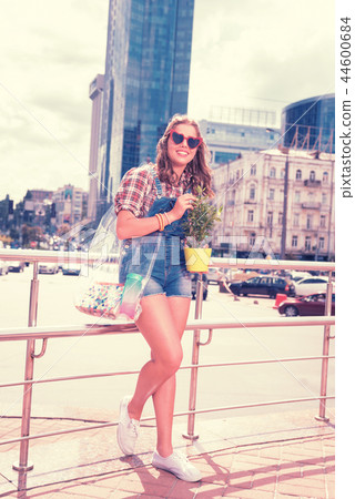 Caring loving daughter holding beautiful home plant after shopping day Caring loving daughter holding beautiful home plant after shopping day 44600684