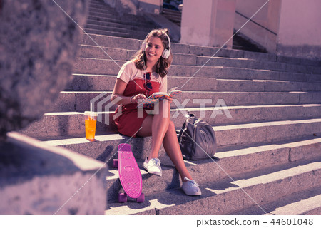 Young girl feeling amazing while chilling sitting in the city center 44601048