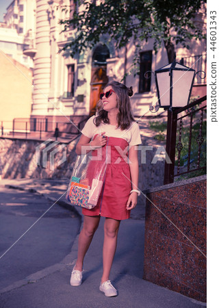 Dark-haired happy student heading to the university with her transparent bag 44601343