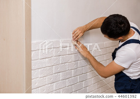 Professional Builder gluing decorative tile on wall. 44601392