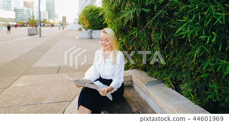Lady reading newspaper outdoors in with close up face. Lady reading newspaper outdoors in with close up face. 44601969