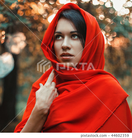 Girl in a red dress standing in the garden  44602359