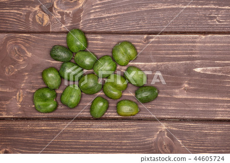Fresh green mini baby kiwi fruit on brown wood Fresh green mini baby kiwi fruit on brown wood 44605724