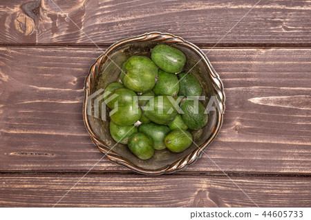 Fresh green mini baby kiwi fruit on brown wood Fresh green mini baby kiwi fruit on brown wood 44605733