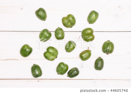 Fresh green mini baby kiwi fruit on grey wood Fresh green mini baby kiwi fruit on grey wood 44605748