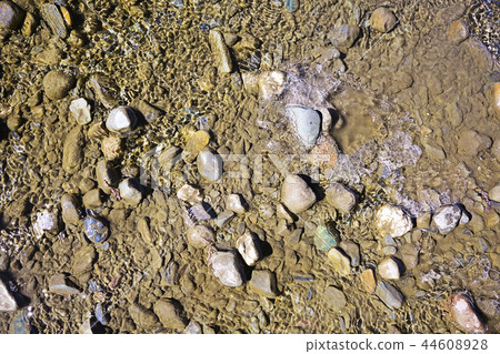 texture of water on stones in a crooked stream 44608928