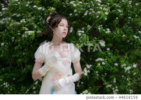 Young woman in elegant long dress white in flowers Young woman in elegant long dress white in flowers 44618159