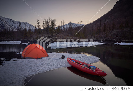 Campsite with orange tent and canoe on a lake Campsite with orange tent and canoe on a lake 44619859