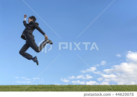 One young businessman in a suit who runs in the air against the blue sky. Health, health, development, challenge image 44620078