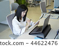Review paperwork while working on the notebook 44622476