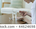 Middle-aged woman drinking supplements 44624698