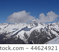 Snowy montain peaks with clouds and blue sky photo 44624921