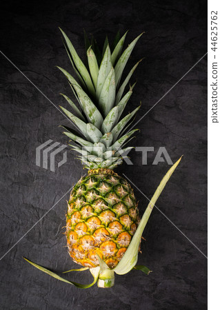 Fresh single ripe pineapple on dark background Fresh single ripe pineapple on dark background 44625762