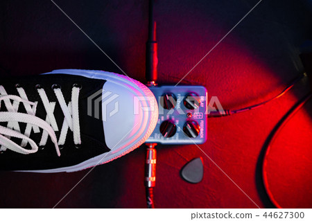 Close up of guitar player foot pressing pedal. Musician uses music effect loop machine. Man in 44627300