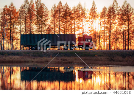 Red truck on a road at sunset 44631098