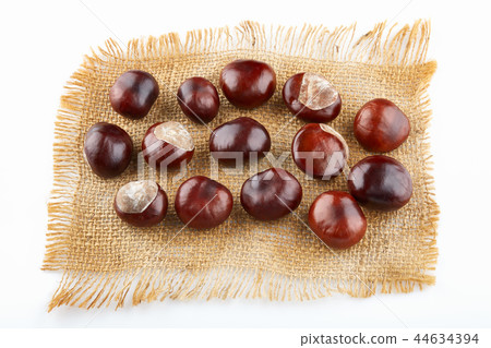 Many peeled chestnuts lie on hessian 44634394