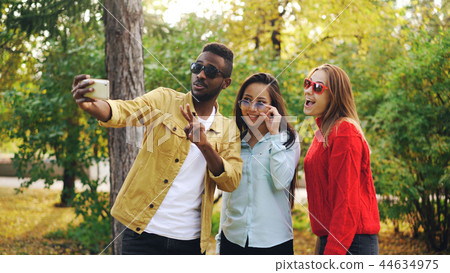 Stylish young people man and women are taking selfie wearing sunglasses posing and smiling holding Stylish young people man and women are taking selfie wearing sunglasses posing and smiling holding 44634975