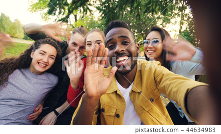 Point of view shot of cheerful students making online video call calling friends holding device Point of view shot of cheerful students making online video call calling friends holding device 44634983