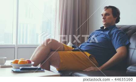 Handsome man watching a match in apartment Handsome man watching a match in apartment 44635160