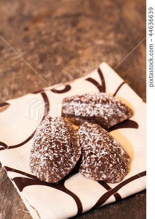 Chocolate madeleines lying on a towel on the old Chocolate madeleines lying on a towel on the old 44636639