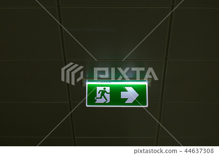 Green emergency exit sign showing the way to escap 44637308