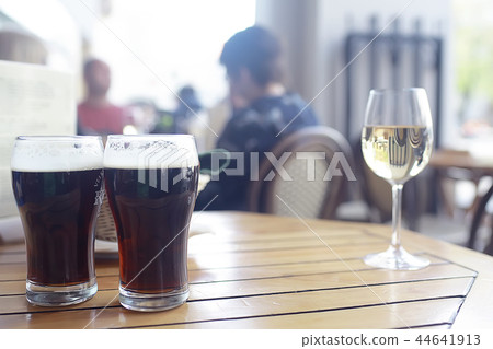 mug of dark beer in the interior of pub / pint of beer with foam on a served table in beer restaurant in Czech Republic mug of dark beer in the interior of pub / pint of beer with foam on a served table in beer restaurant in Czech Republic 44641913