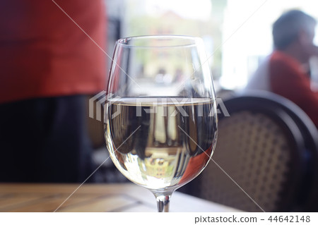 glass of white wine in the restaurant / white wine in the interior of the restaurant a table with glasses of wine, a romantic summer glass of white wine in the restaurant / white wine in the interior of the restaurant a table with glasses of wine, a romantic summer 44642148