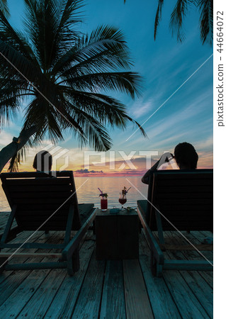 Woman sit on beach chair having cocktail drink  44664072