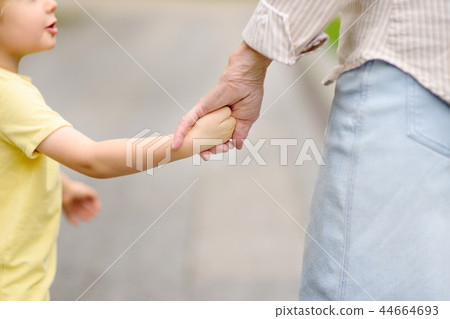 Beautiful granny and her little grandchild together walking Beautiful granny and her little grandchild together walking 44664693