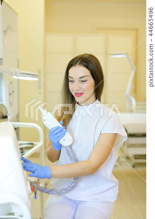 Caucasian permanent makeup artist sitting with laser removal device at beauty salon. 44665496