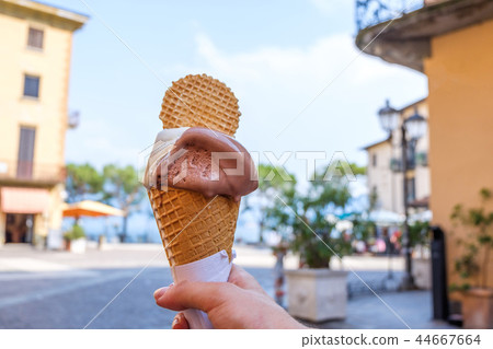 Woman hands holding ice-cream with waffle Woman hands holding ice-cream with waffle 44667664