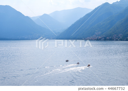 Three boats cruising parallel on water 44667732