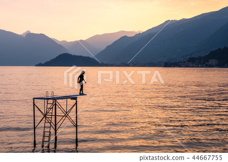 Silhouette of a woman trying to jump into water Silhouette of a woman trying to jump into water 44667755