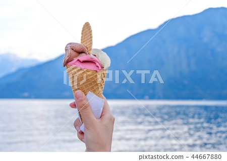 Woman hand holding ice cream with waffle Woman hand holding ice cream with waffle 44667880