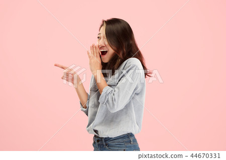 The young woman whispering a secret behind her hand over pink background The young woman whispering a secret behind her hand over pink background 44670331