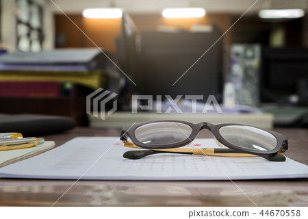 A eye glasses on report documents in office 44670558