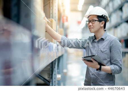 Asian man doing stocktaking on tablet in warehouse Asian man doing stocktaking on tablet in warehouse 44670643