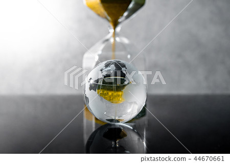 Hourglass and world globe crystal on the table 44670661